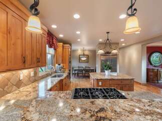 Experience luxury in this spacious kitchen featuring custom wood cabinetry and stunning granite countertops.