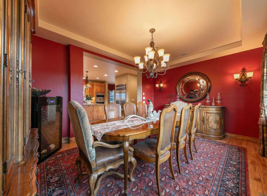 Experience elegant dining in this luxurious home, featuring a formal dining room with a grand wooden table and plush seating, perfect for hosting memorable gatherings.