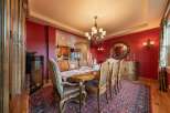 Experience elegant dining in this luxurious home, featuring a formal dining room with a grand wooden table and plush seating, perfect for hosting memorable gatherings.