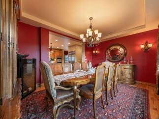 Experience elegant dining in this luxurious home, featuring a formal dining room with a grand wooden table and plush seating, perfect for hosting memorable gatherings.