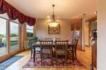 Experience elegant dining in this charming room, featuring a rustic wooden table and chairs set on a beautiful floral rug.