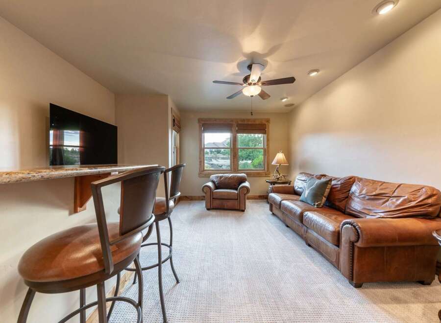 Experience ultimate relaxation in this inviting living space, featuring a plush leather sofa and a cozy armchair perfect for unwinding.