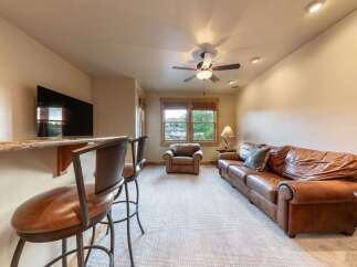 Experience ultimate relaxation in this inviting living space, featuring a plush leather sofa and a cozy armchair perfect for unwinding.