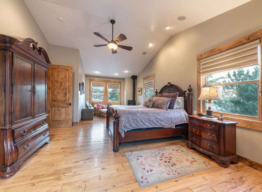 Experience rustic elegance in this spacious bedroom featuring a grand wooden armoire and a matching dresser.