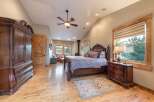 Experience rustic elegance in this spacious bedroom featuring a grand wooden armoire and a matching dresser.