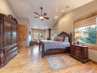 Experience rustic elegance in this spacious bedroom featuring a grand wooden armoire and a matching dresser.