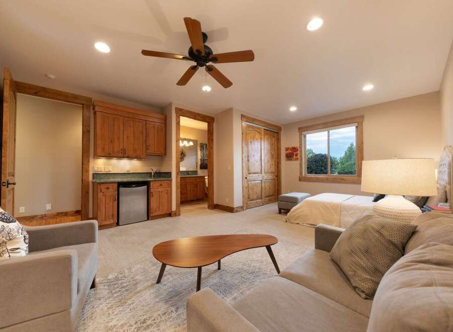 This spacious room offers a comfortable living area with a plush sofa and a unique coffee table, perfect for relaxation.