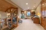Experience rustic elegance in this spacious home featuring a grand staircase with intricate railings and exposed wooden beams.