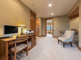 This spacious hallway features a dedicated home office area with a wooden desk, computer, and printer, perfect for remote work.