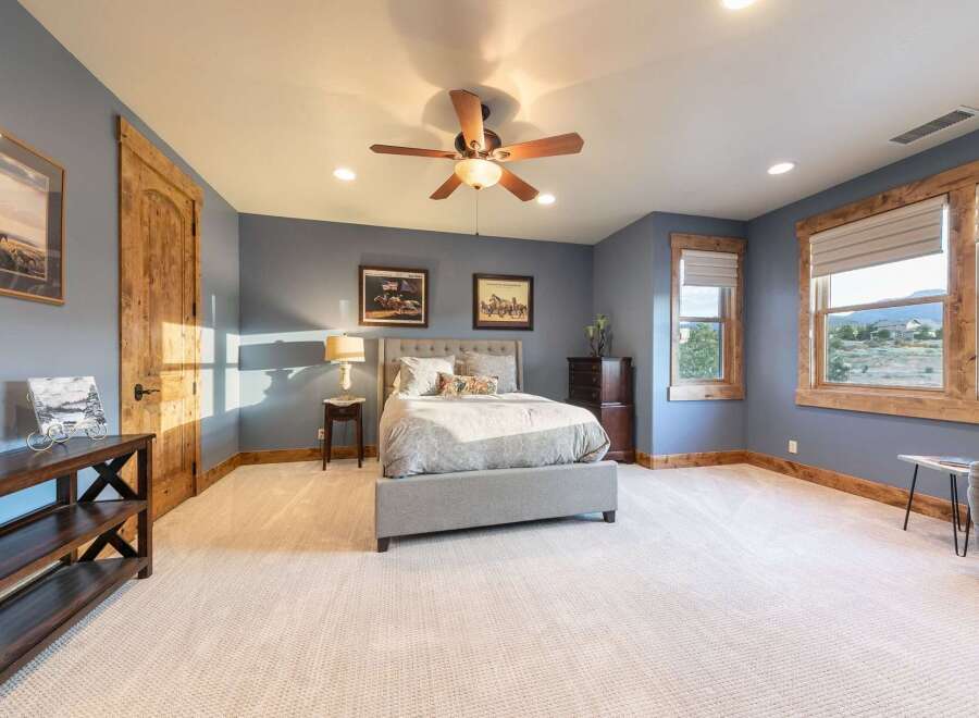 Experience rustic charm in this inviting bedroom, featuring a plush king-sized bed with a tufted headboard and elegant patterned bedding.