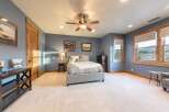 Experience rustic charm in this inviting bedroom, featuring a plush king-sized bed with a tufted headboard and elegant patterned bedding.