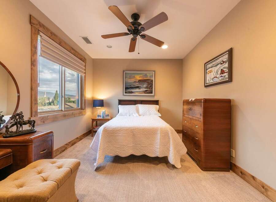 Experience comfort and style in this inviting bedroom, featuring a plush queen-size bed adorned with a quilted white comforter.
