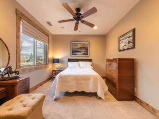 Experience comfort and style in this inviting bedroom, featuring a plush queen-size bed adorned with a quilted white comforter.