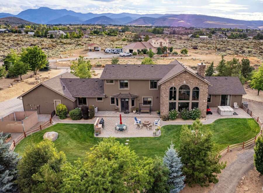Experience luxury living in this expansive estate, featuring a stunning stone-accented facade and a sprawling backyard perfect for entertaining.