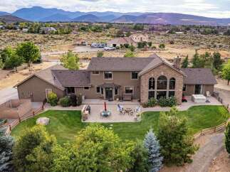 Experience luxury living in this expansive estate, featuring a stunning stone-accented facade and a sprawling backyard perfect for entertaining.