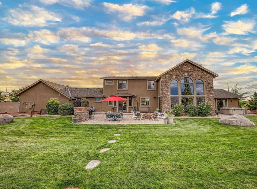 Experience luxurious outdoor living with this stunning backyard featuring a spacious patio, a built-in grill, and a cozy fire pit perfect for entertaining.