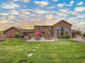 Experience luxurious outdoor living with this stunning backyard featuring a spacious patio, a built-in grill, and a cozy fire pit perfect for entertaining.