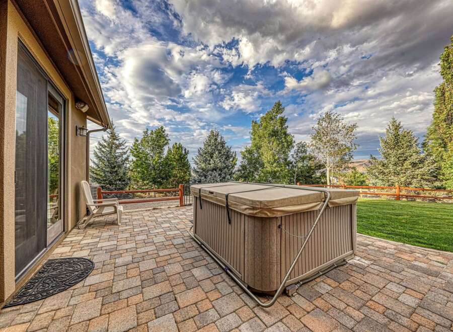 Enjoy outdoor living at its finest with this spacious patio featuring a luxurious hot tub, perfect for relaxation and entertaining.