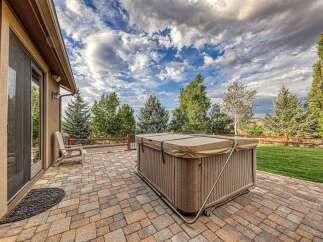 Enjoy outdoor living at its finest with this spacious patio featuring a luxurious hot tub, perfect for relaxation and entertaining.