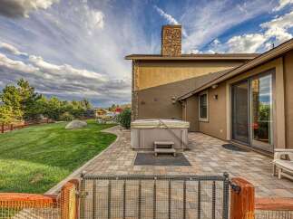 Enjoy outdoor living with this spacious backyard featuring a luxurious hot tub perfect for relaxation.