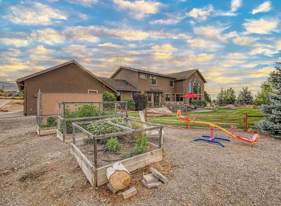 Discover this stunning property featuring a spacious home with a stone-accented facade and large arched windows, perfect for enjoying the scenic views.