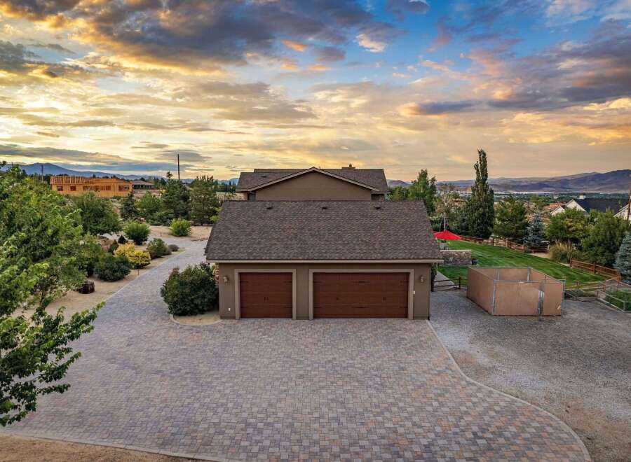 Discover this stunning property featuring a spacious paver driveway leading to a three-car garage, perfect for car enthusiasts or ample storage.