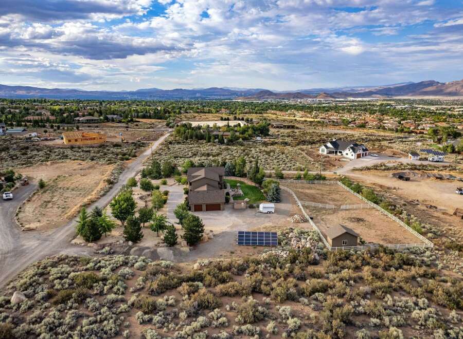 Discover this expansive property featuring a spacious main residence with a three-car garage, complemented by a detached workshop and ample space for RV parking.