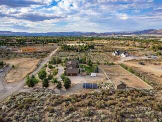Discover this expansive property featuring a spacious main residence with a three-car garage, complemented by a detached workshop and ample space for RV parking.