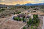Experience luxury living in this expansive estate, featuring a stunning main residence with a grand stone fireplace and large windows offering breathtaking mountain views.