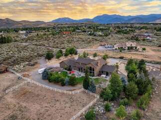 Experience luxury living in this expansive estate, featuring a stunning main residence with a grand stone fireplace and large windows offering breathtaking mountain views.