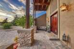 Welcome guests to this stunning property with a charming stone-accented porch and a grand wooden front door.