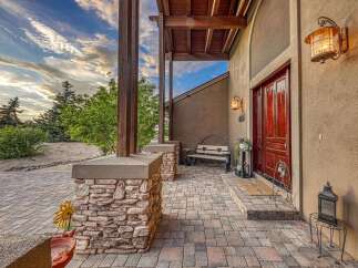 Welcome guests to this stunning property with a charming stone-accented porch and a grand wooden front door.