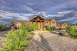 Discover this stunning luxury home featuring a grand entrance with a covered wooden porch and stone accents.