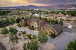 Experience luxury living in this stunning estate, featuring a grand entrance with a covered porch and stone accents.