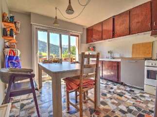 Enjoy breathtaking mountain views from this charming kitchen and dining area, featuring a spacious table perfect for family meals.