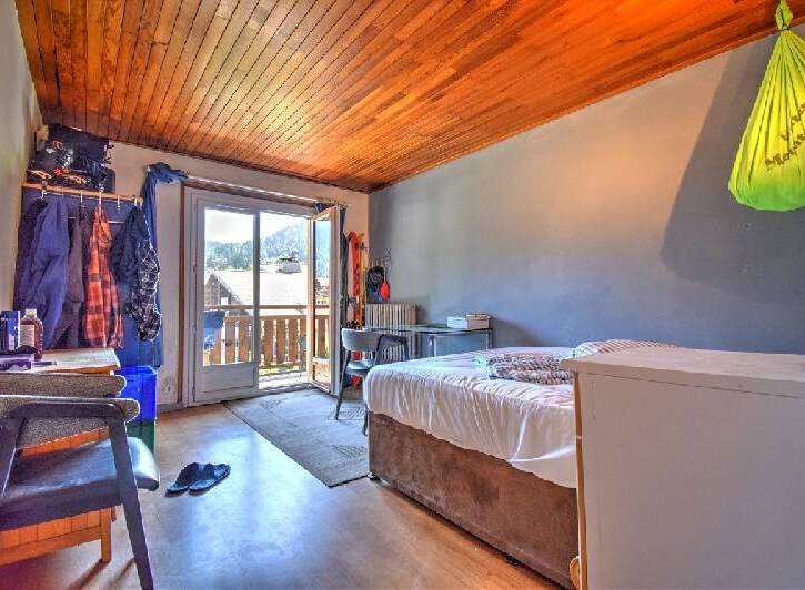 Discover this charming room featuring a cozy bed and a convenient desk area, perfect for work or study.