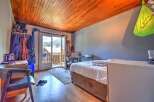 Discover this charming room featuring a cozy bed and a convenient desk area, perfect for work or study.