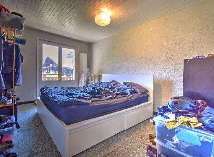 This cozy bedroom features a comfortable bed with a white headboard, perfect for a restful night's sleep.