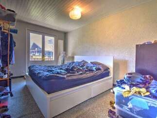 This cozy bedroom features a comfortable bed with a white headboard, perfect for a restful night's sleep.