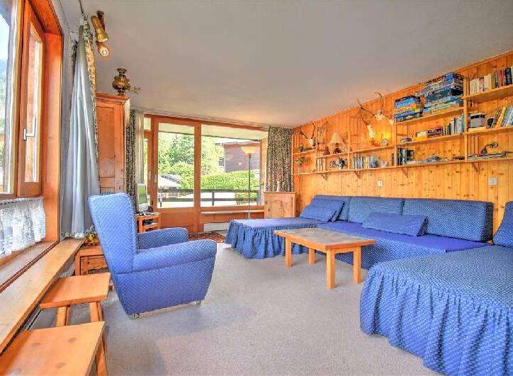 This charming living room features a comfortable blue sectional sofa and a matching armchair, perfect for relaxing.