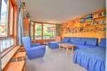 This charming living room features a comfortable blue sectional sofa and a matching armchair, perfect for relaxing.