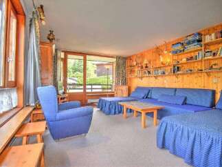 This charming living room features a comfortable blue sectional sofa and a matching armchair, perfect for relaxing.