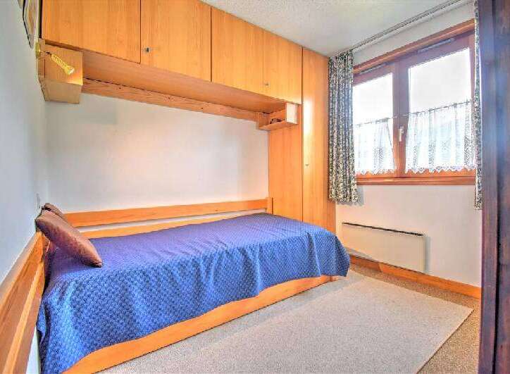This cozy bedroom features a built-in bed with a vibrant blue comforter, perfect for a restful night's sleep.