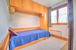 This cozy bedroom features a built-in bed with a vibrant blue comforter, perfect for a restful night's sleep.