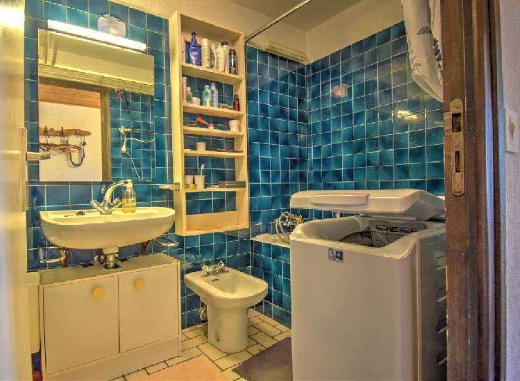 Discover this charming bathroom featuring vibrant blue tiled walls and a practical layout.