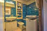 Discover this charming bathroom featuring vibrant blue tiled walls and a practical layout.
