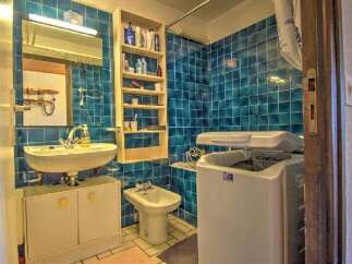 Discover this charming bathroom featuring vibrant blue tiled walls and a practical layout.