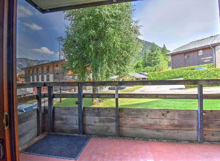 Enjoy the fresh mountain air from this charming balcony with a rustic wooden railing and a welcoming doormat.