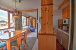 Enjoy scenic mountain views from this charming dining area, featuring a large wooden table and chairs perfect for family meals.