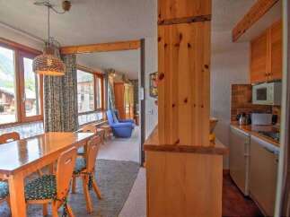 Enjoy scenic mountain views from this charming dining area, featuring a large wooden table and chairs perfect for family meals.